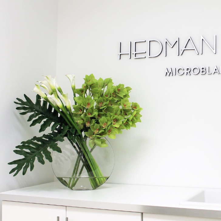 Lunar Vase with green Cymbidium orchids and Calla lilies.